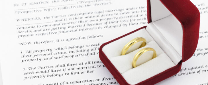 Form of prenuptial agreement with a pair of wedding rings in a red box