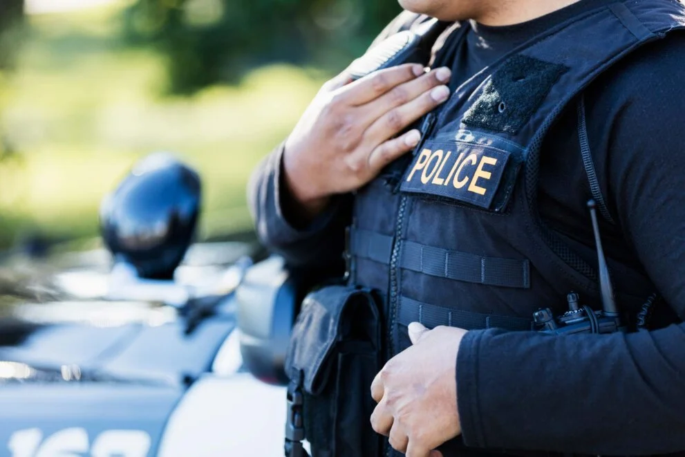 Close up of police officer wearing tactical vest with hand over his chest