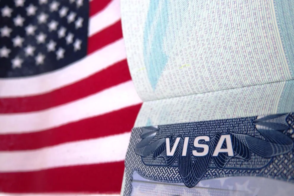 Close up of a US visa with an American Flag in the background