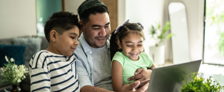 Father with his kids using laptop and mobile phone