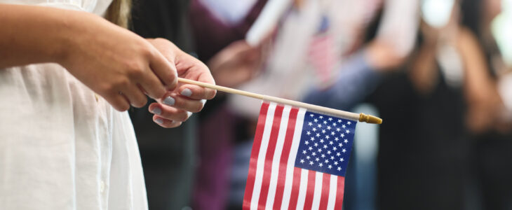 woman in white dress holding American flag