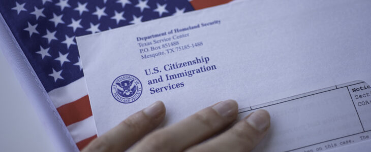 etter (Envelope) from USCIS and left hand on flag of USA background