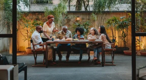 Family gathered around a table outside on the patio